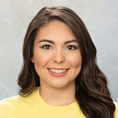 Young Woman Smiling By Green Wall