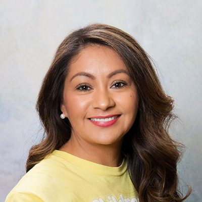 Young Woman Smiling By Green Wall