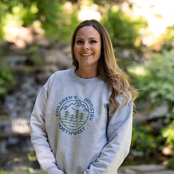 Young Woman Smiling By Green Wall