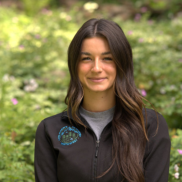 Young Woman Smiling By Green Wall