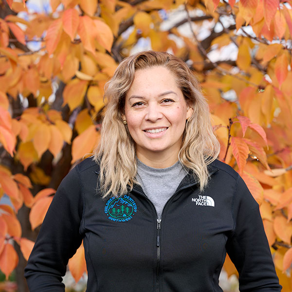 Lucy Young Woman Smiling By Green Wall