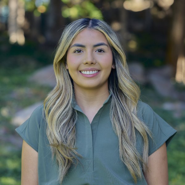 Young Woman Smiling By Green Wall